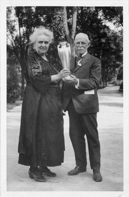 Edith and Henry Carr smile and pose with a tall golden cup.