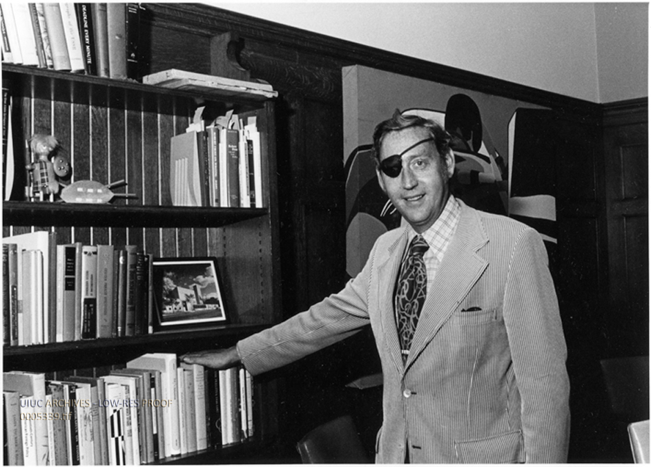 Photograph of Hugh C. Atkinson posed in front of a bookshelf from the University of Illinois Archives