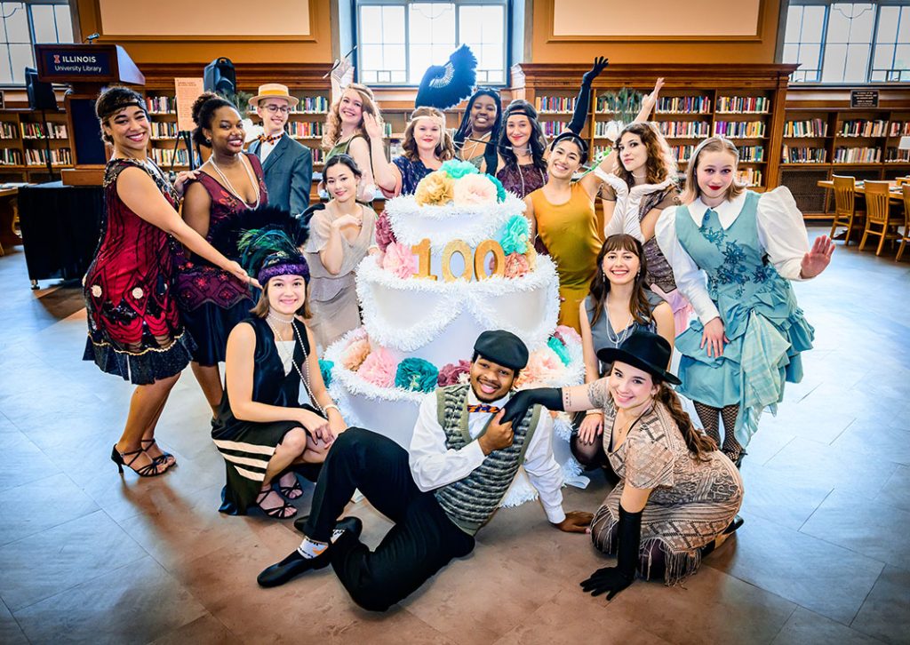 1920s performers surround 100th anniversary cake