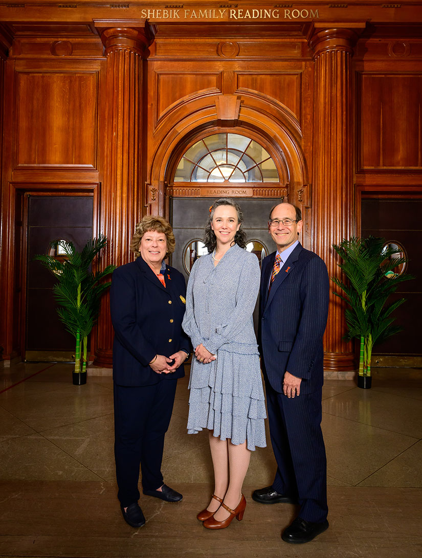 Steve and Megan Shebik stand in front of the Shebik Family Reading Room entrance with Dean Claire Stewart