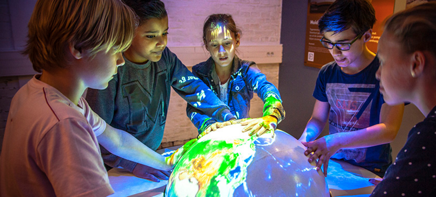 Photo of students touching an illuminated globe. Credit: NandoBennis / CC BY-SA