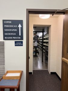 Picture of doorway with accompanying sign with an arrow reading: Copier, periodicals, newspapers, microfilm, and reader printers.