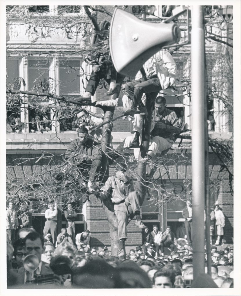 Students climbed trees and leaned out windows to hear Kennedy speak on the Quad.